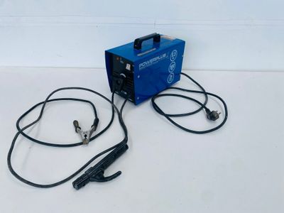 an electric welding machine sitting on top of a table next to a pair of headphones
