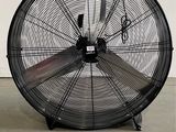 un ventilateur posé par terre à côté d'un sac