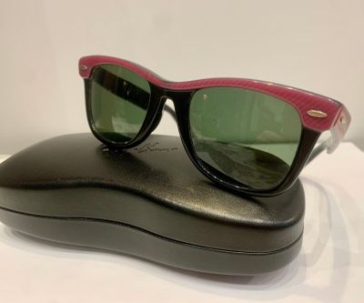 RAY BAN. Paire de lunettes de soleil monture noire dessus et…