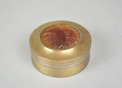 une petite boîte en or sur laquelle figure le portrait d'une femme