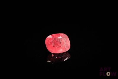 a close up of a pink diamond on a black surface