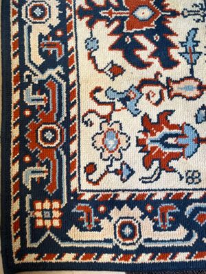 une photo d'un tapis bleu et rouge posé sur un parquet