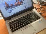 a laptop computer sitting on top of a wooden desk