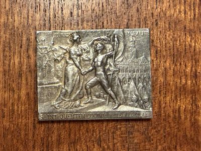 a close up of a metal plaque on a wooden surface