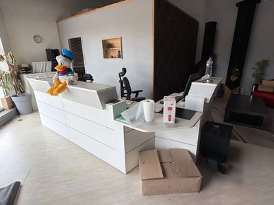 une pièce avec un bureau, une chaise et un ordinateur portable posé par terre