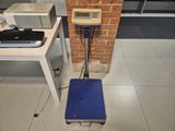 a small scale sitting on the floor next to a printer