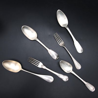 five silver spoons and two silver spoons on a black surface