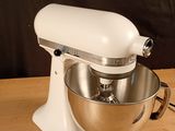 a white mixer on a wooden table with a black background