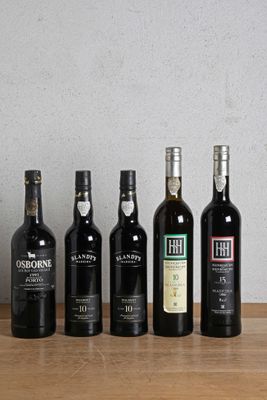 several bottles of wine are lined up on a wooden table