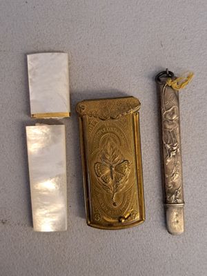 a lighter, a lighter case, and a knife on a table