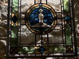 a stained glass window in the corner of a stone wall