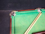 a pool table with two cues and a ball on it