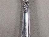 a silver spoon with a crown on it sitting on a table