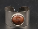 bracelet manchette en argent orné d'une pierre rouge au centre