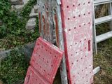 a ladder leaning against a stone wall next to a pile of old doors