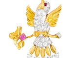 une photo d'une broche en forme d'oiseau en or et diamants, ornée d'une pierre rose