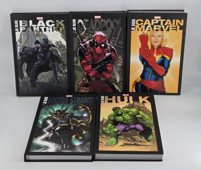 a set of four books on a white surface with a black background