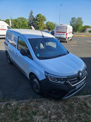 une camionnette blanche garée dans un parking à côté d'autres camionnettes