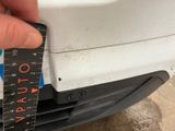 someone is measuring the width of the front bumper of a car