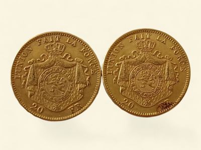 gros plan de deux pièces d'or sur une surface blanche