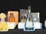 many different perfumes on a table with a black background
