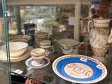 une vitrine en verre contenant de nombreux modèles de tasses à thé et de soucoupes
