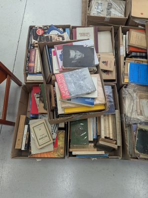 de nombreuses caisses de livres empilées les unes sur les autres par terre