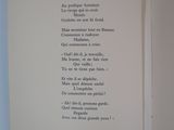 an open book with a poem on it on a blue surface