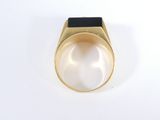 a close up of a gold ring with a black stone in the middle