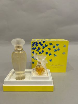 a small bottle of perfume sitting on a tray next to a box