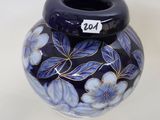 a blue vase with blue flowers on it on a white surface