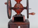 un moulin à café rouge posé sur une caisse en bois