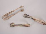 three silver spoons and two silver spoons on a white surface