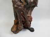 une statue représentant un homme assis sur une souche d'arbre