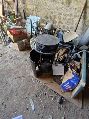 a pile of junk on the ground next to a wall