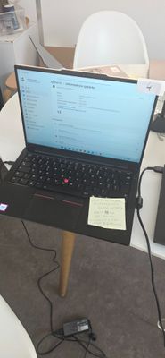 un ordinateur portable posé sur une table, entouré de nombreux câbles