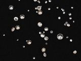 a close up of a bunch of diamonds on a black surface