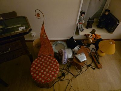 une photo d'un salon encombré, avec beaucoup d'objets éparpillés par terre