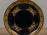 a black plate with gold and blue designs on it
