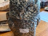 une statue représentant un hibou perché sur une table en bois