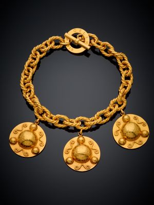 une photo d'un bracelet en or orné de quatre breloques