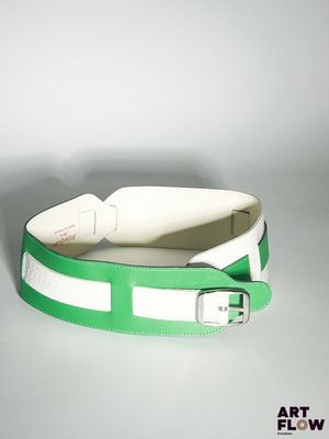 ceinture en cuir vert et blanc, dotée d'une boucle métallique sur un fond blanc