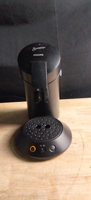 une cafetière noire posée sur une table en bois