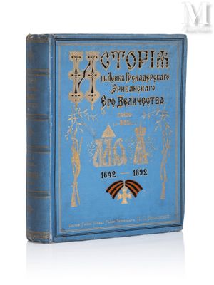 un vieux livre bleu orné d'inscriptions dorées, posé sur une surface blanche