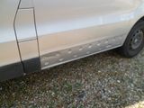 a silver van with holes on the side of it