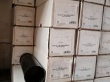 a stack of boxes and a black pipe in the middle of a room