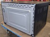 an image of a microwave sitting on a dolly in a warehouse