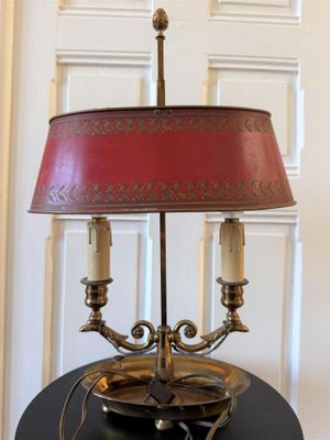 une lampe posée sur une table, avec un abat-jour rouge