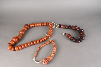 collier composé de perles en bois avec un fermoir en argent sur fond gris