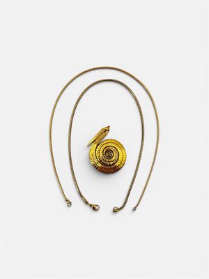 un collier plaqué or orné d'un motif en spirale sur une chaîne